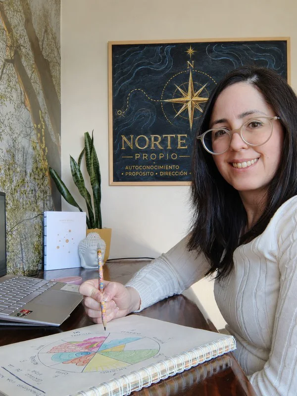 Anabel Sánchez Gómez sonriendo junto al cartel de Norte Propio, con su cuaderno de carta natal